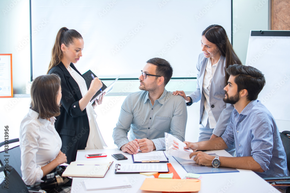 Business people at meeting table in conference room discussing work and planning strategy. Business people at meeting table in conference room discussing work and planning strategy.