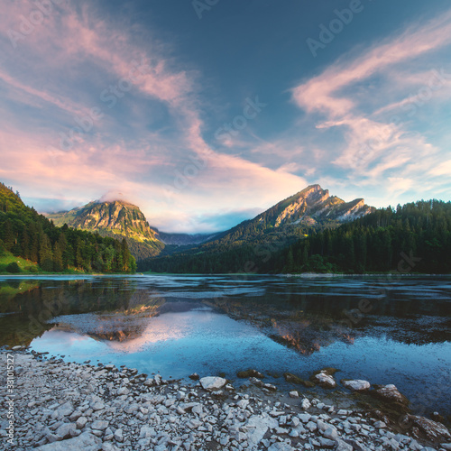 Fototapeta Naklejka Na Ścianę i Meble -  Peaceful summer view on Obersee lake in Swiss Alps. Sunrise sky and mountains reflections in clear water. Nafels village, Switzerland. Landscape photography