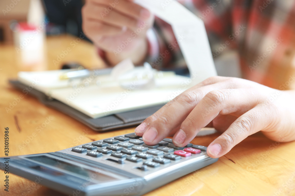 businessman using calculator and holding bill for calculate tax in office. businessman using calculator and holding bill for calculate tax in office.