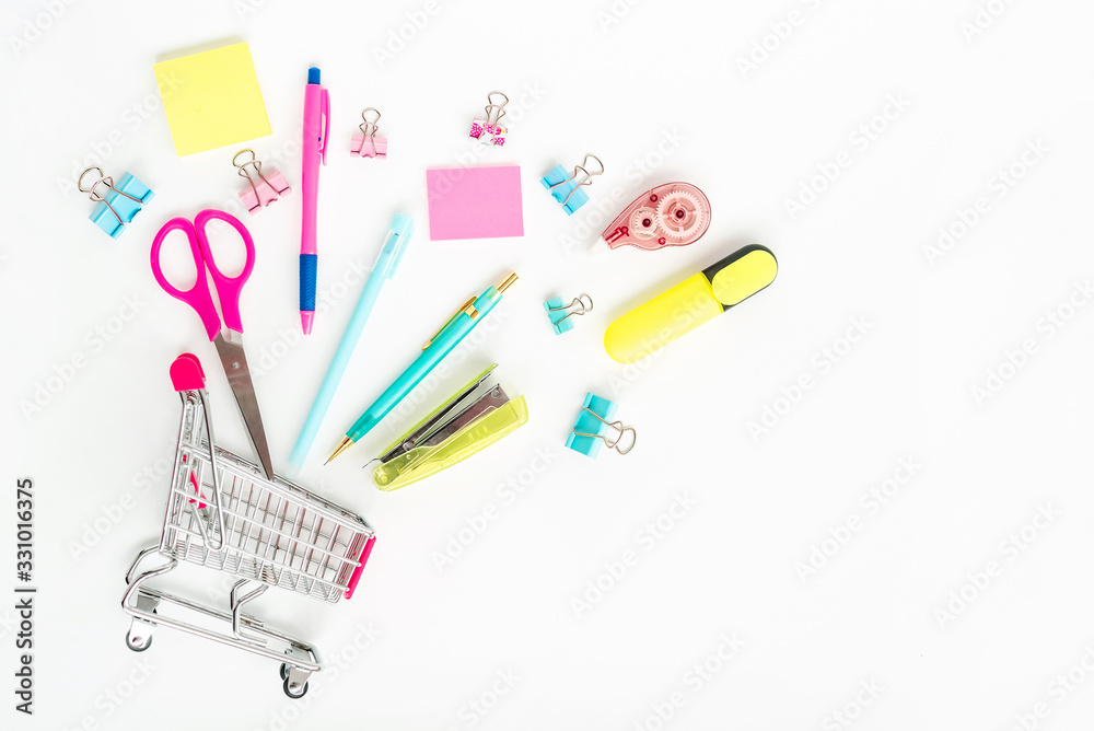 Bright stationery objects in mini supermarket cart on white background Bright stationery objects in mini supermarket cart on white background