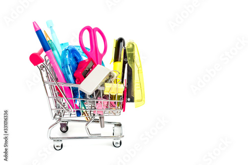Bright stationery objects in mini supermarket cart on white background
