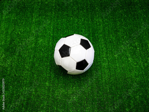 Classic black and white soccer ball on green artificial grass  alone