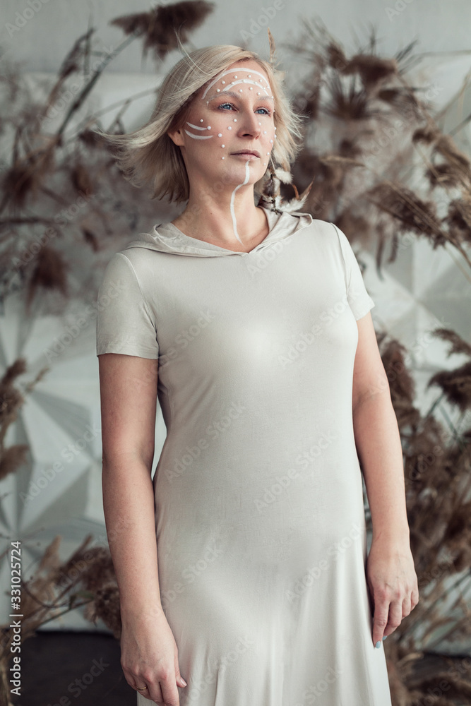 Woman with make-up stands with white hair developing in the wind Woman with make-up stands with white hair developing in the wind