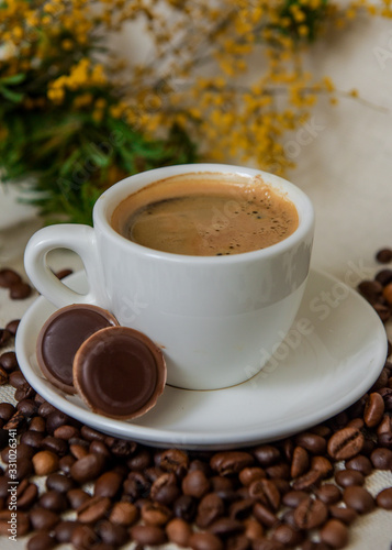 A cup of fresh espresso with chocolates. Coffee beans. Morning coffee concept