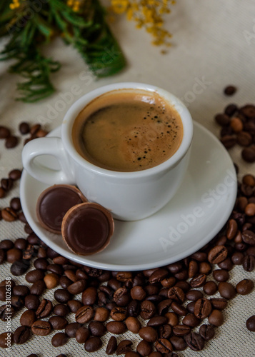 A cup of fresh espresso with chocolates. Coffee beans. Morning coffee concept