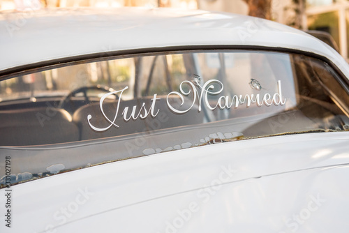 Fotografie Bullet holes in car windshield with Just Married sign for newlyweds