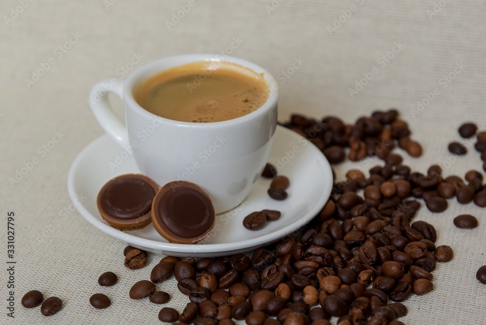 A cup of fresh espresso with chocolates. Coffee beans. Morning coffee concept A cup of fresh espresso with chocolates. Coffee beans. Morning coffee concept