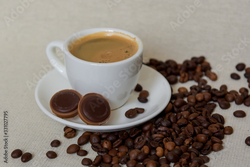 A cup of fresh espresso with chocolates. Coffee beans. Morning coffee concept