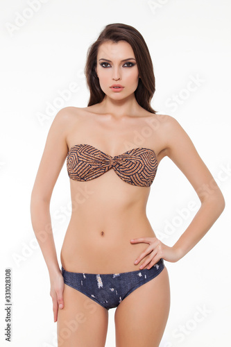 beautiful girl posing in stylish chic bikini on white background.