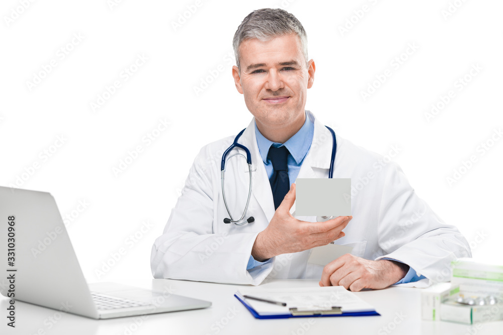 Smiling doctor displaying a box of medication Smiling doctor displaying a box of medication