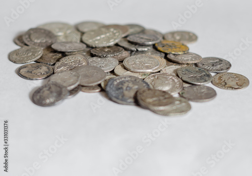 Antique Roman coins, a small pile of cash on a white background