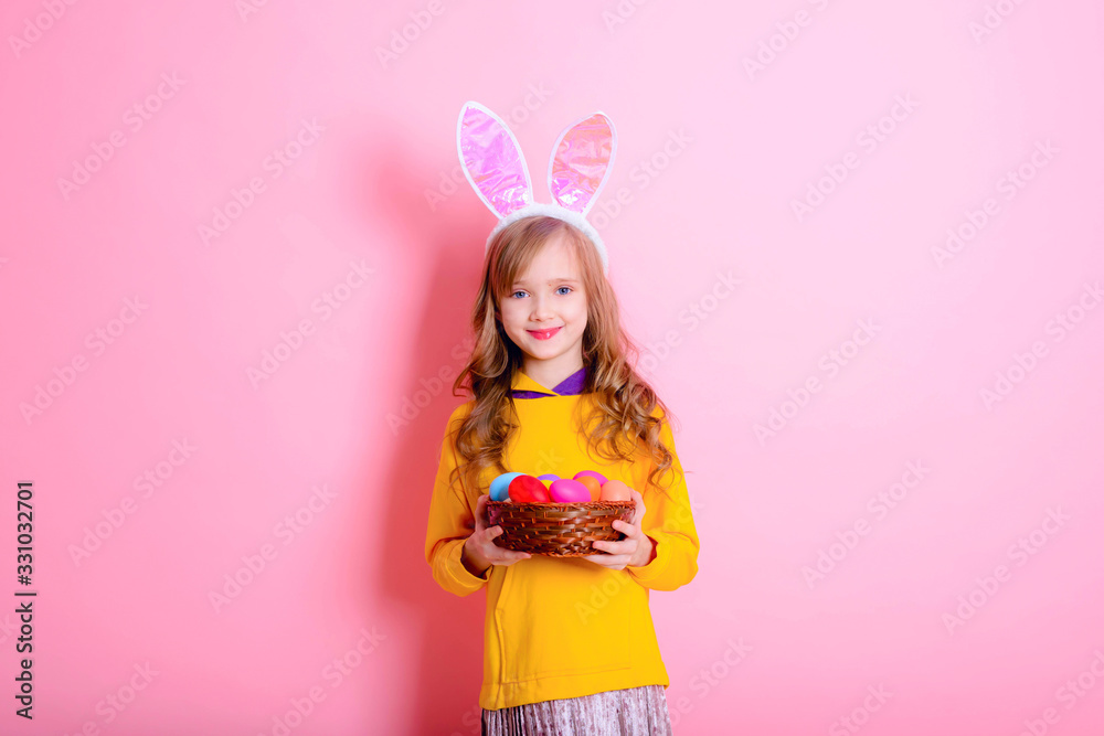 Happy Easter! Little girl having fun to paint Easter eggs.