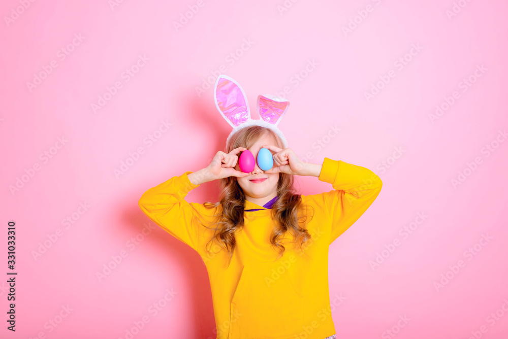 Happy Easter! Cute girl kid blonde with Bunny ears holds bright Easter eggs. Traditions, holidays, spring, religion concept. Happy Easter! Cute girl kid blonde with Bunny ears holds bright Easter eggs. Traditions, holidays, spring, religion concept.