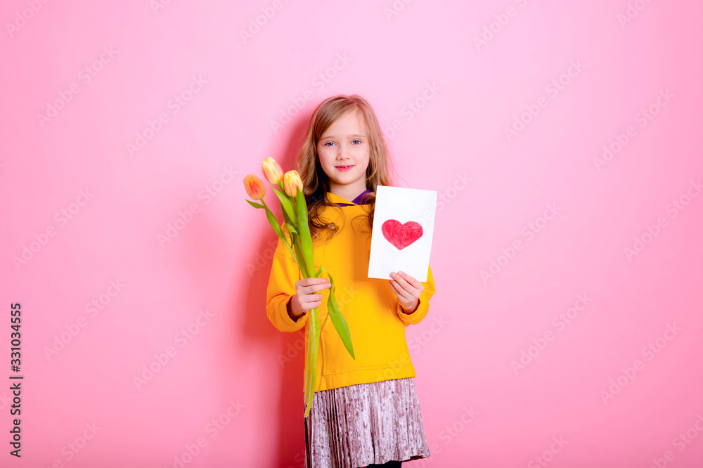 Happy Easter! Girl kid blonde in rabbit ears holding a card red heart, yellow tulips. Happy Mother's Day! International Women Day. Daughter's day. Happy Easter! Girl kid blonde in rabbit ears holding a card red heart, yellow tulips. Happy Mother's Day! International Women Day. Daughter's day.