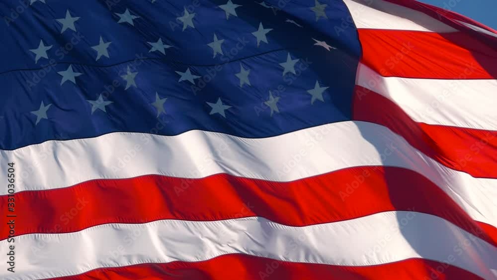 CLOSE UP, SLOW MOTION: American flag waving in wind video footage Realistic USA Flag background. American Flag. Waved highly detailed fabric texture. American flag flying in the wind at sunny day CLOSE UP, SLOW MOTION: American flag waving in wind video footage Realistic USA Flag background. American Flag. Waved highly detailed fabric texture. American flag flying in the wind at sunny day