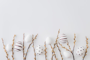 Flat lay easter composition with a willow branch and eggs on a white background