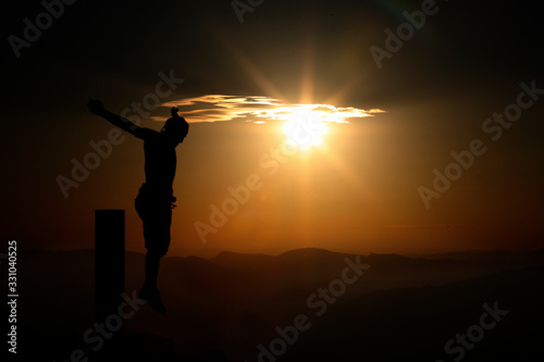 Fototapeta crucified man in mountains at sunset
