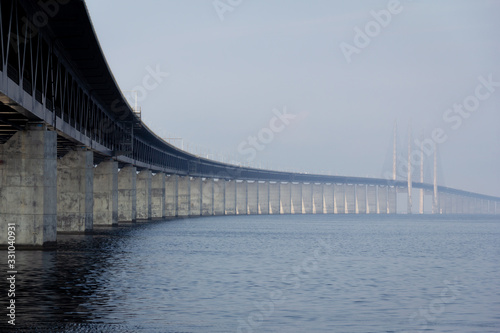 A low perspective of the Oresund bridge stretching out to the sea and the fog