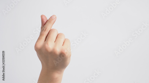 Male model is doing mini heart hand sign with backhand on white background. © nisara