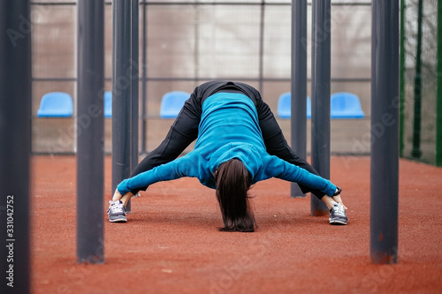 Bild auf Leinwand A young woman is engaged in sports on the Playground.
