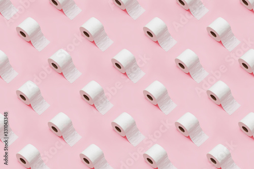 Rolls of white toilet paper on pink background. photo
