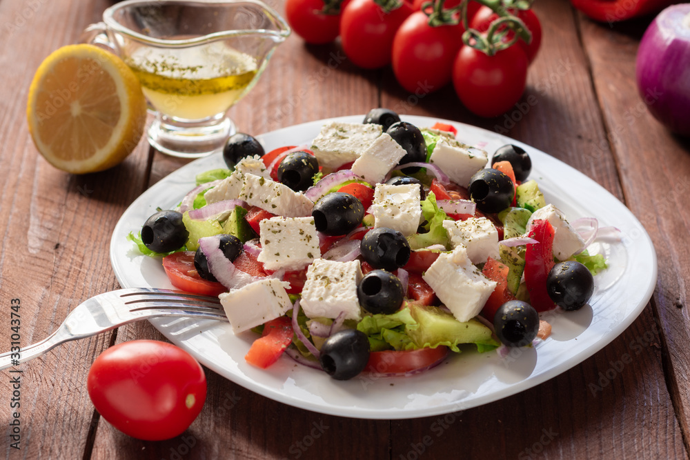 Greek salad with fresh cucumber , tomatoes, sweet pepper, lettuce, red onion, feta cheese and olives with olive oil. Healthy diet