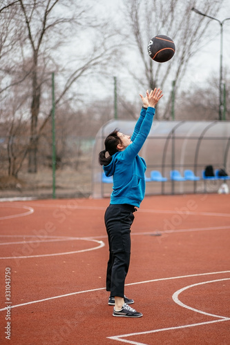 A young woman is engaged in sports on the Playground. Exercises with the medicine balls on the outdoor.