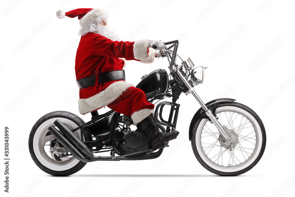 Full length profile shot of Santa Claus riding a custom chopper motorbike Full length profile shot of Santa Claus riding a custom chopper motorbike