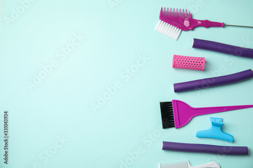 Professional tools for hair dyeing on light blue background, flat lay. Space for text