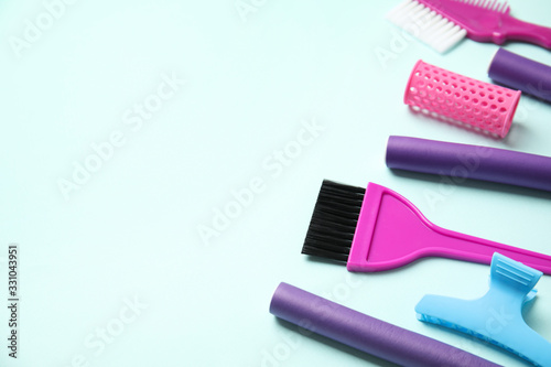 Professional tools for hair dyeing on light blue background  space for text