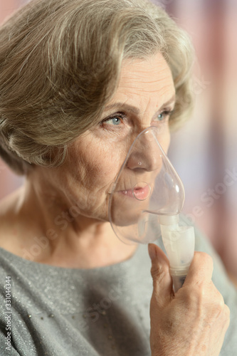 Portrait of elderly woman with flu inhalation