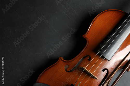 Photo Classic violin and bow on black stone background, top view