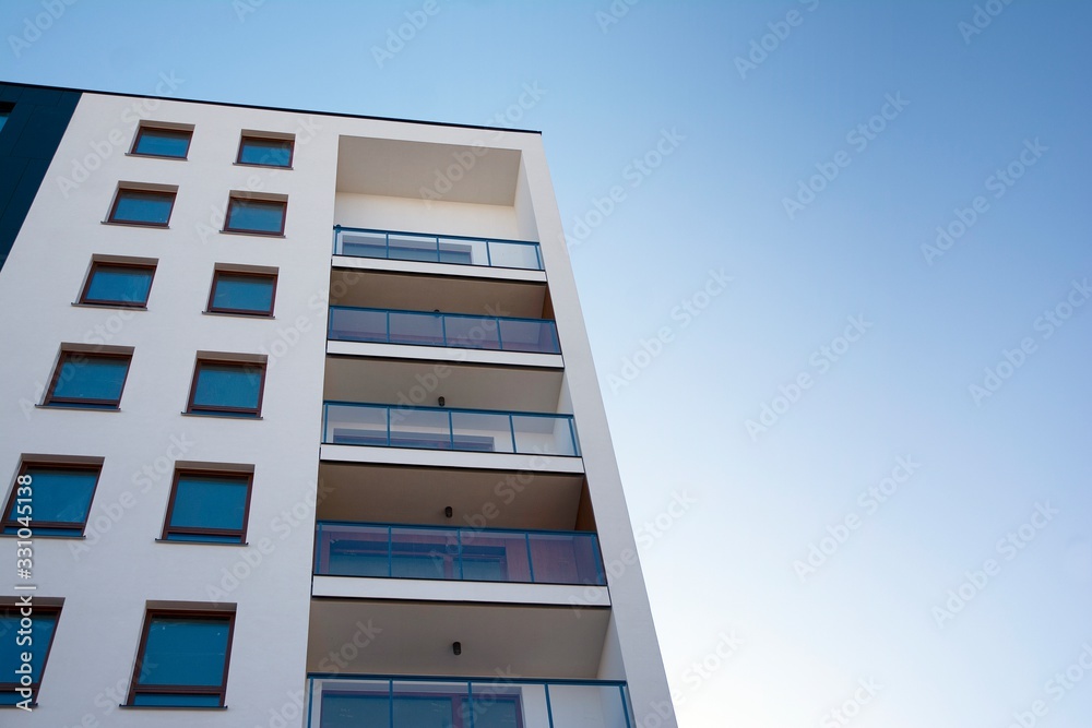 Modern apartment buildings on a sunny day with a blue sky. Facade of a modern apartment building Modern apartment buildings on a sunny day with a blue sky. Facade of a modern apartment building
