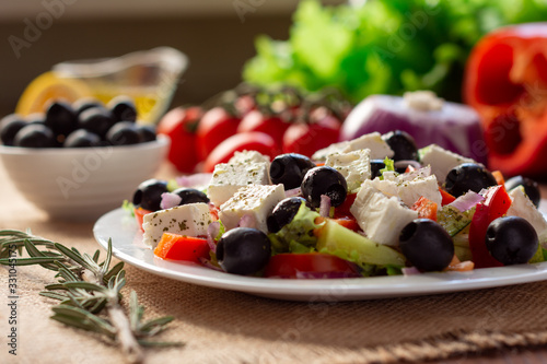Greek salad with fresh cucumber , tomatoes, sweet pepper, lettuce, red onion, feta cheese and olives with olive oil. Healthy diet