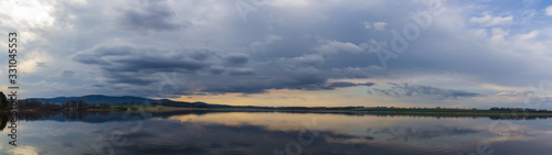 Panoramic view to pond with dramatic overcast sky. Nice reflection in water  Czech landscape