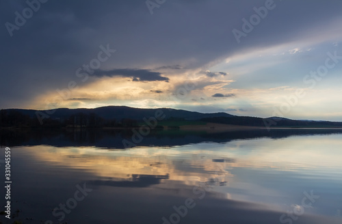 Clear pond with dramatic overcast sky. Nice reflection in water, Czech landscape © Space Creator