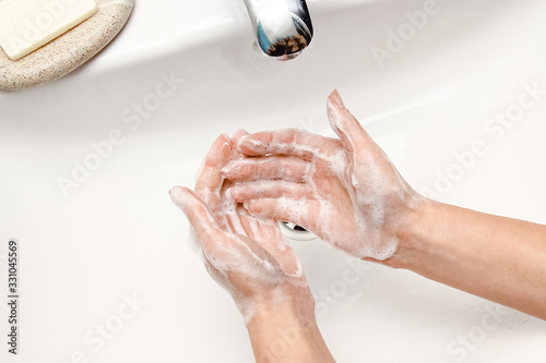 a Washing hands with soap under the faucet with water