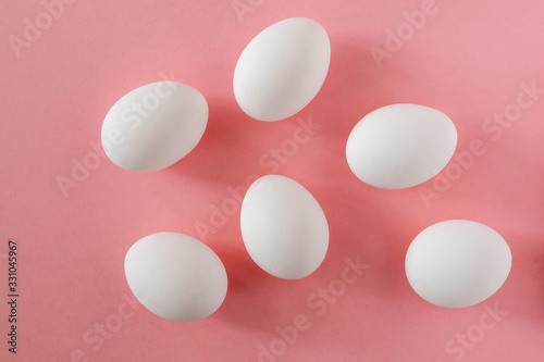 Six white eggs on a pink background. Easter, spring, ingredients for cooking concept. Horizontal orientation.
