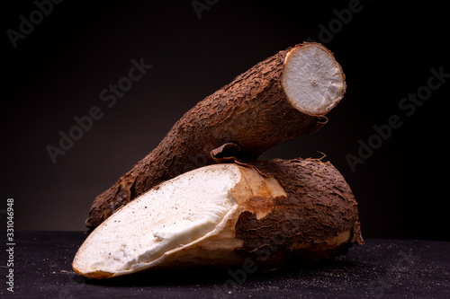 Картината върху платно Unprepared Cassava roots with textured bark and white edible inside