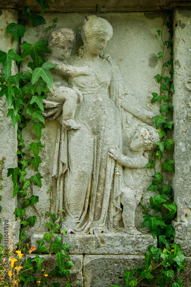 Fototapeta premium Antique stone statue of Woman with children as symbol of Сharity (Haritas).