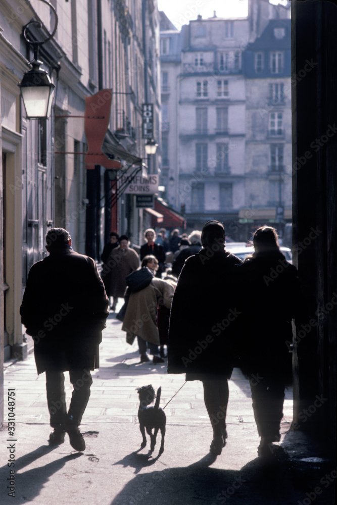 Pedestrians on Paris sidewalk with dog