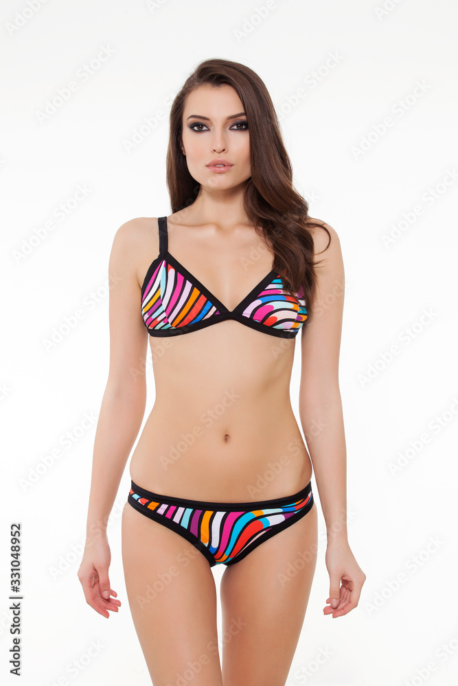 beautiful girl posing in stylish detailed black and colorful bikini on white background. beautiful girl posing in stylish detailed black and colorful bikini on white background.