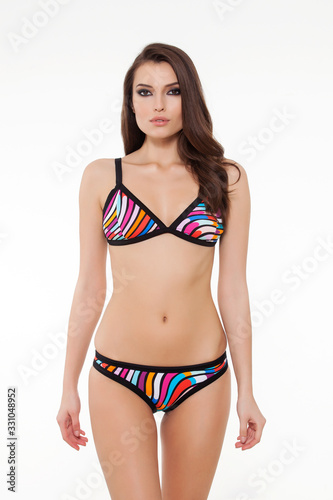 beautiful girl posing in stylish detailed black and colorful bikini on white background.