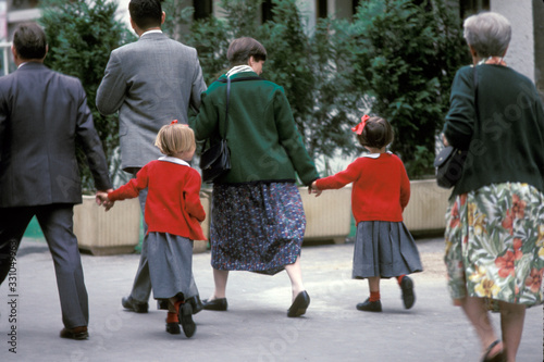 Family walking with two young daughters wearing identical red jackets