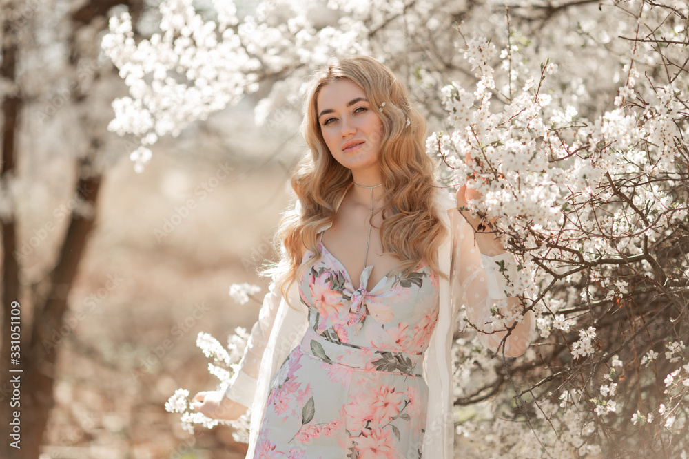Pretty woman in blossom spring garden