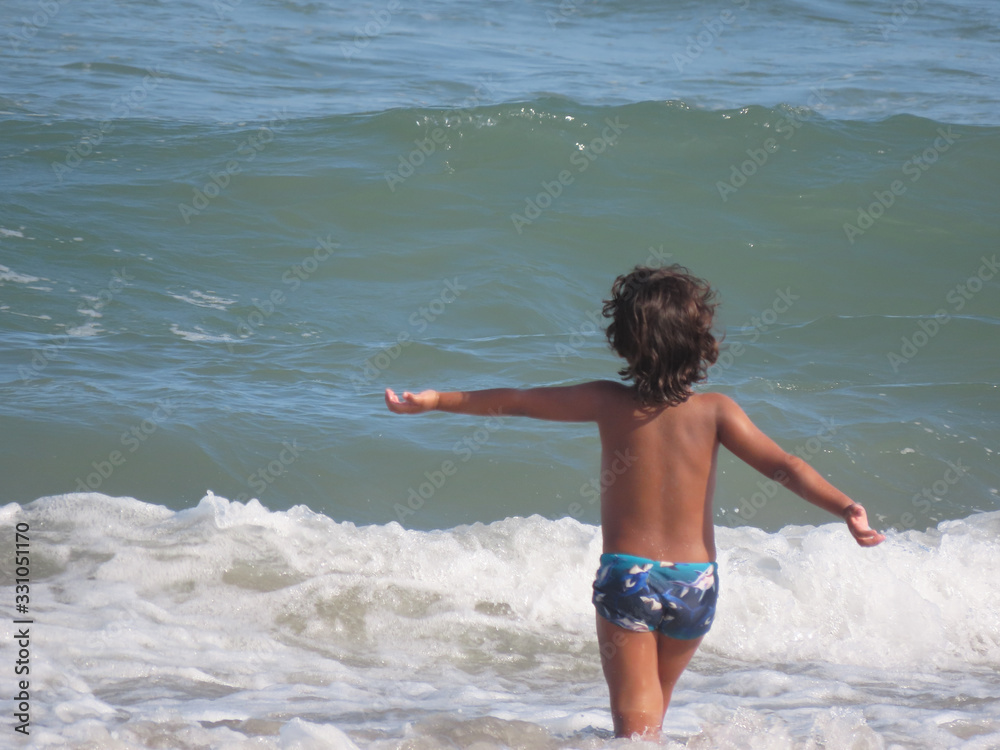 Fototapeta premium Child with open arms when entering the sea