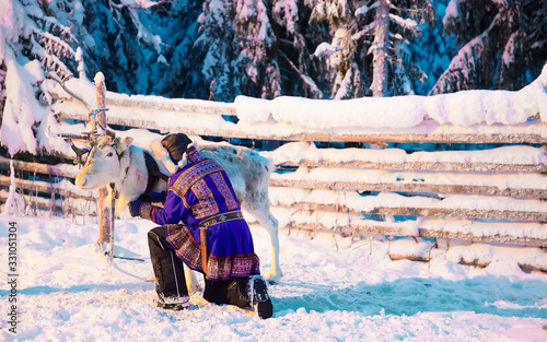 Man in Saami traditional garment at Reindeer Rovaniemi Finland Lapland photo