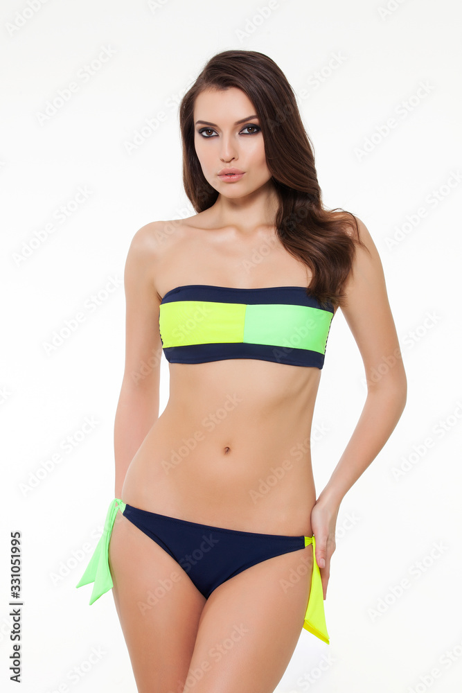 beautiful girl posing in stylish detailed black and neon green bikini on white background. beautiful girl posing in stylish detailed black and neon green bikini on white background.