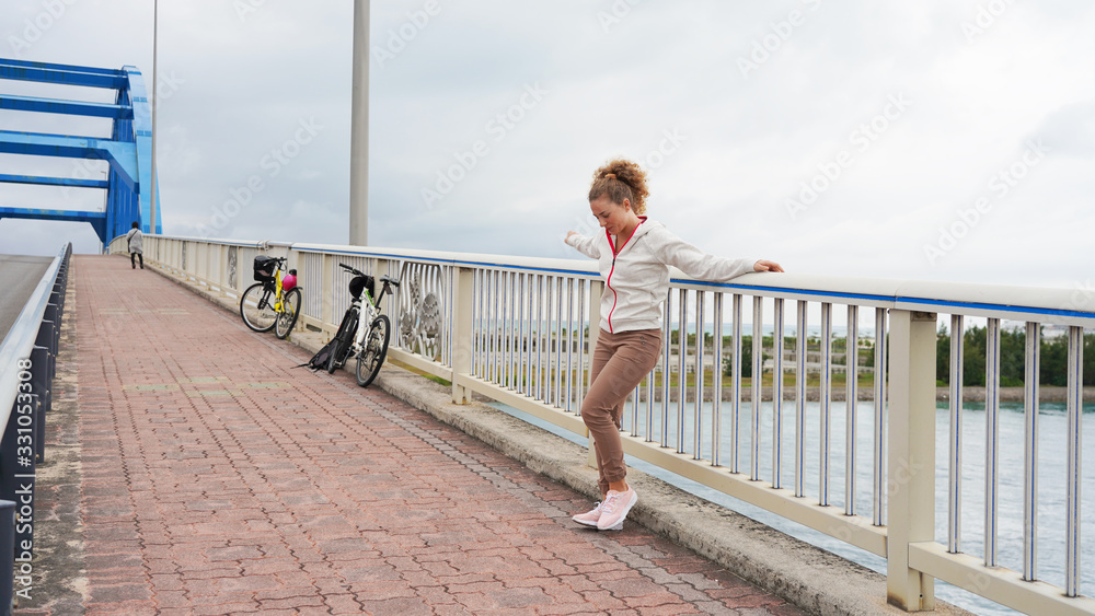 sporty curly-haired girl smiles and travels on a bicycle. outdoor activities. beautiful girl riding a bike. emotions, joy fun. bicycle lane
