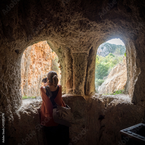 Chica joven haciendo fotografías en unas ventanas de piedra dentro del Monasterio de Piedra de Zaragoza España photo